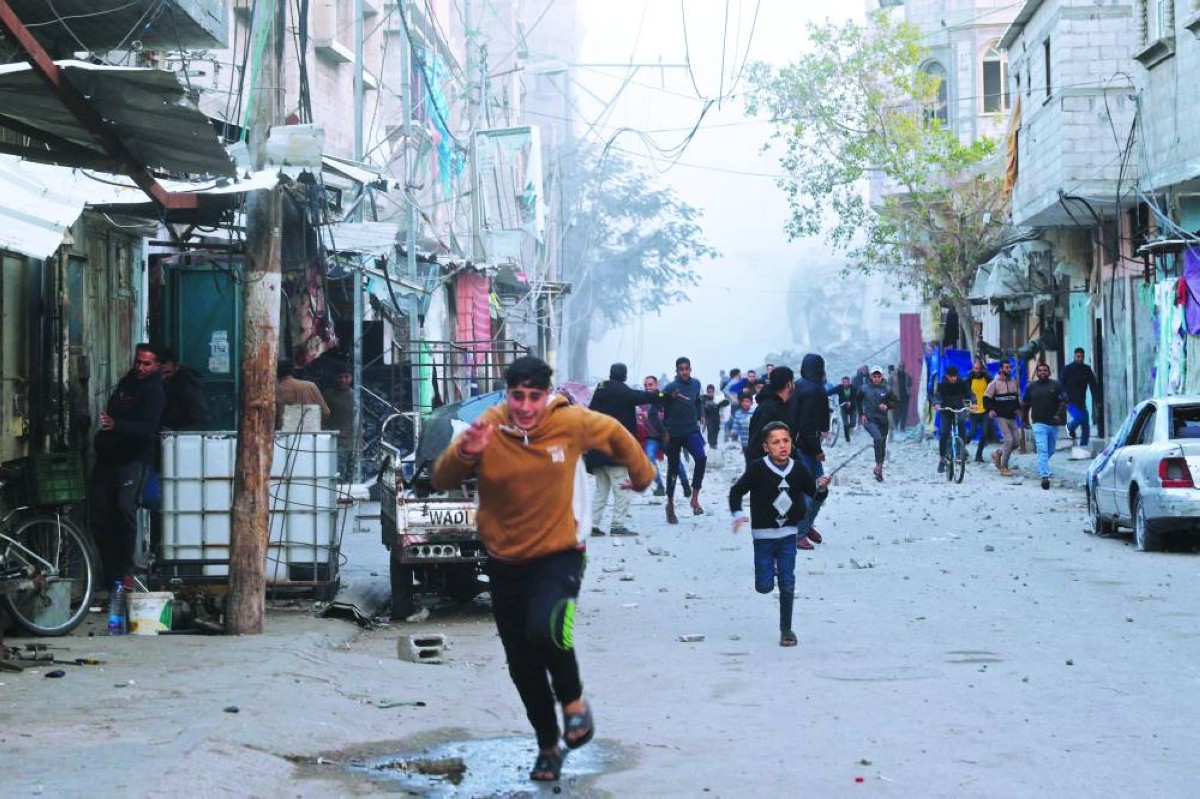 فلسطينيون يركضون للاختباء بعد غارة جوية إسرائيلية على مخيم البريج