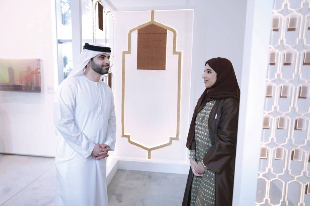 منصور بن محمد يطّلع على تفاصيل أحد أعمال المعرض