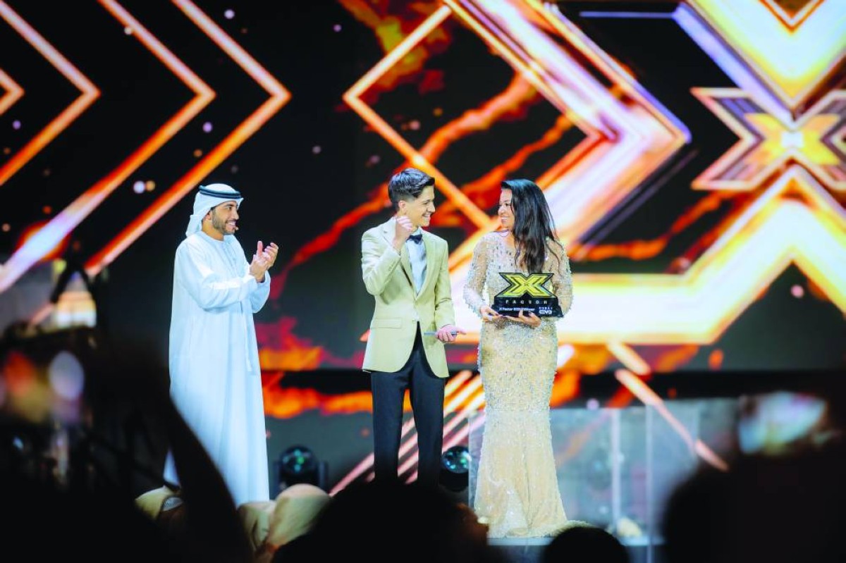 عبدالرحيم الحلبي أثناء تسلّمه من رحمة رياض درع «إكس فاكتور دبي» بحضور عمار آل رحمة 