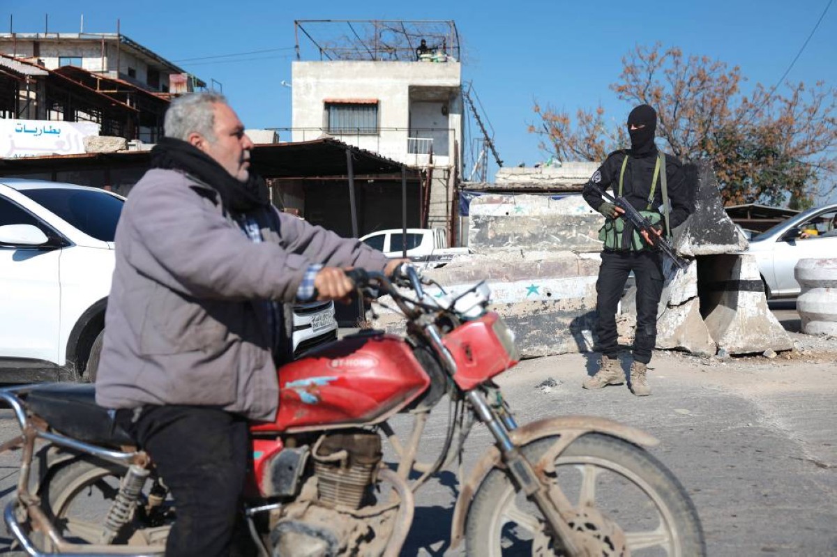 أحد أفراد قوات الأمن السورية يقف عند نقطة تفتيش عند مدخل بلدة جبلة