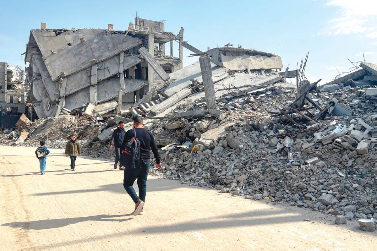 فلسطينيون يسيرون بين أنقاض المنازل المدمرة في خان يونس جنوب قطاع غزة