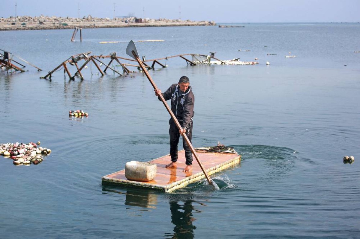 باب ثلاجة وقد تحول إلى مركب صيد يعتليه صياد في بحر غزة |