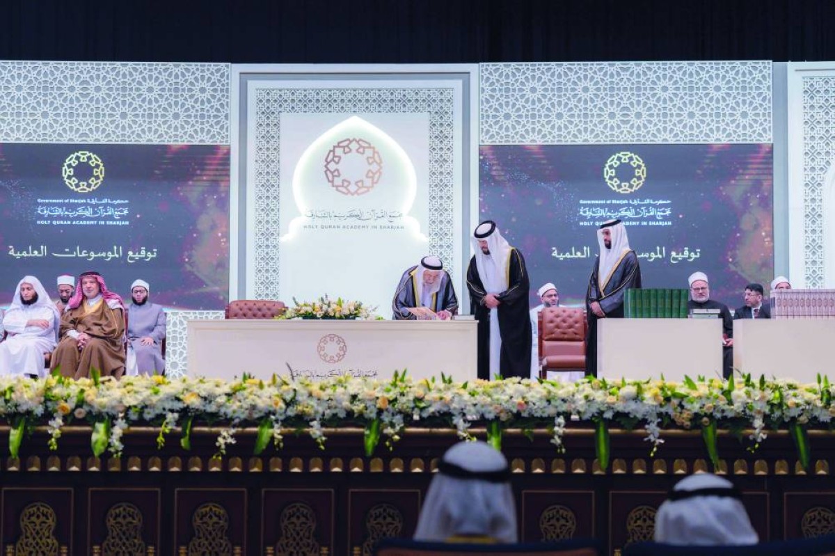 سلطان القاسمي خلال التوقيع على النسخة الأولى من المجلدات بحضور خليفة الطنيجي