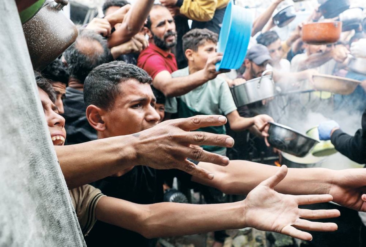 فلسطينيون ينتظرون الحصول على حصة من الطعام في بيت لاهيا شمال قطاع غزة