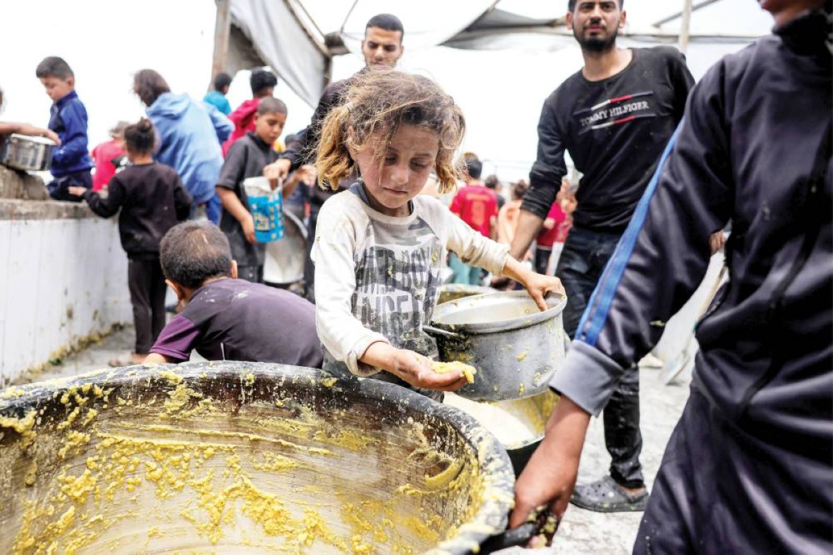 طفلة تلتقط بقايا طعام بعد نفاد المخزون من أحد المطابخ في بيت لاهيا