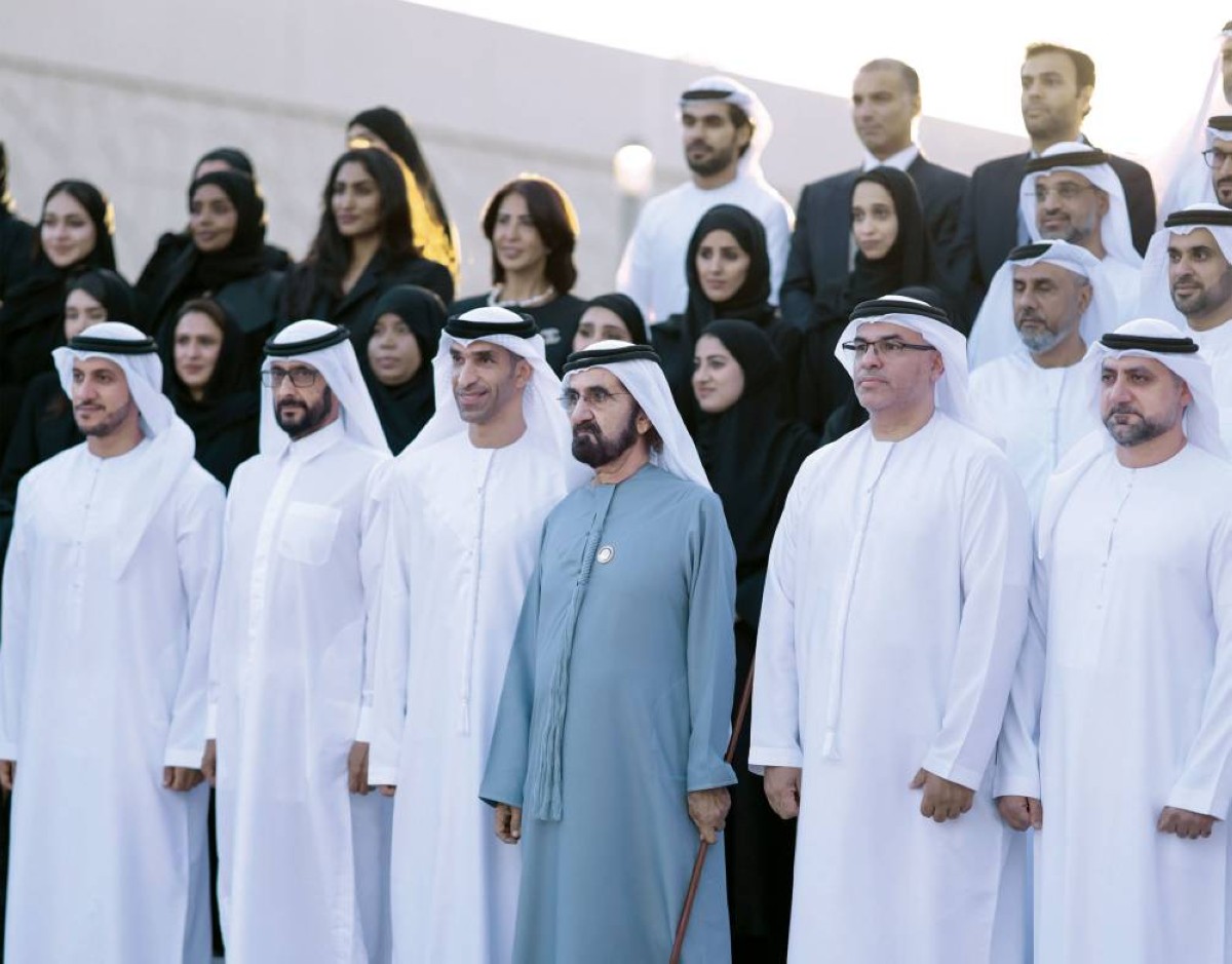 محمد بن راشد في لقطة تذكارية مع فريق عمل المفاوضات الدولية الخاصة بالشراكات الاقتصادية يرافقه أحمد بن راشد وثاني الزيودي
