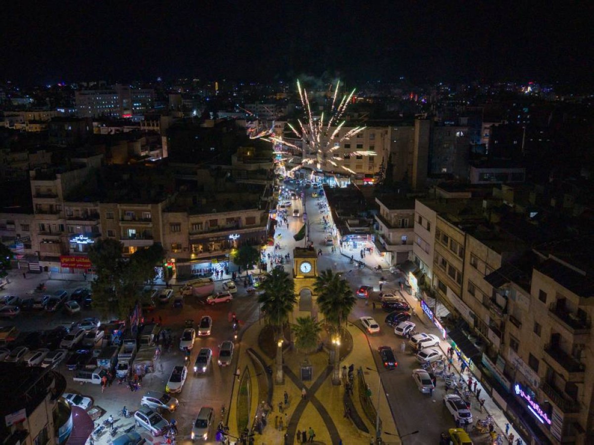 سوريون يشعلون الألعاب النارية احتفالًا في الشارع بعد إعلان الولايات المتحدة رفع العقوبات عن سوريا، في إدلب 