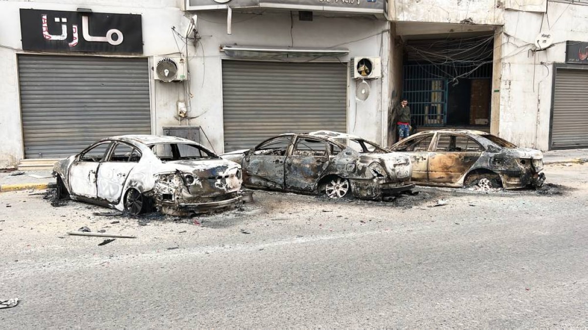 سيارات متضررة في أحد شوارع طرابلس جرّاء الاشتباكات بين الجماعات المسلحة