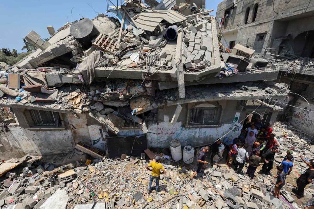 فلسطينيون يتفقدون الأضرار بعد غارة إسرائيلية على مخيم النصيرات