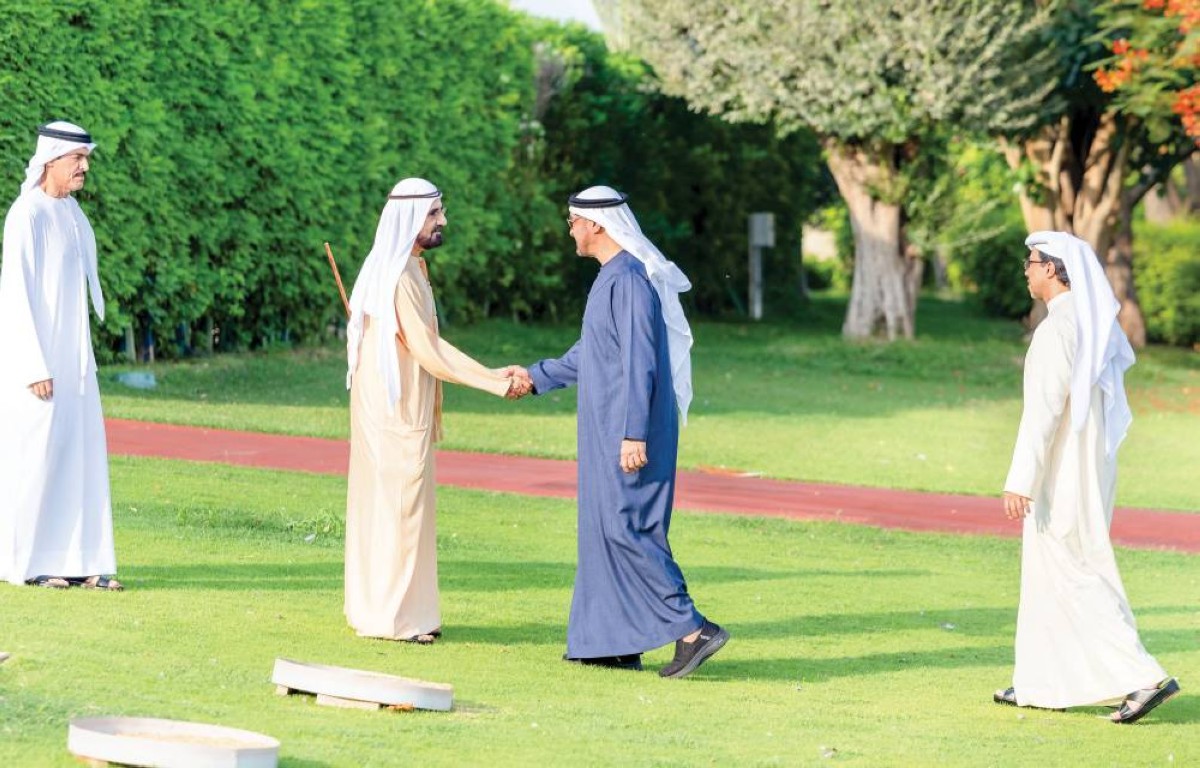  محمد بن زايد مصافحاً محمد بن راشد بحضور منصور بن زايد 