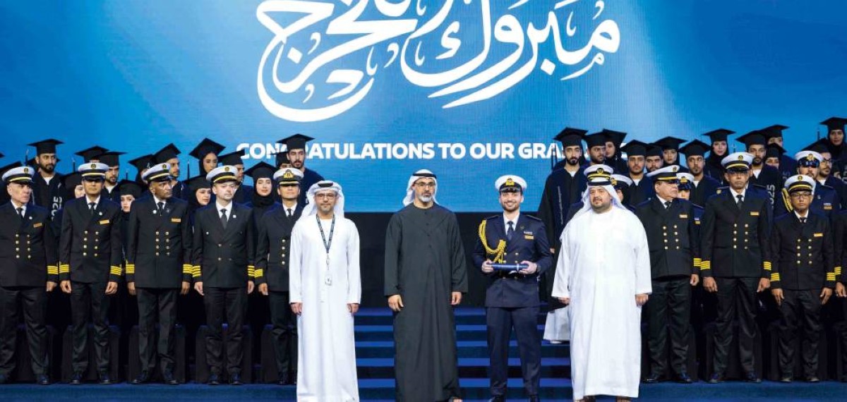 خالد بن محمد متوسطاً الخريجين خلال الحفل بحضور محمد السويدي ومحمد الشامسي