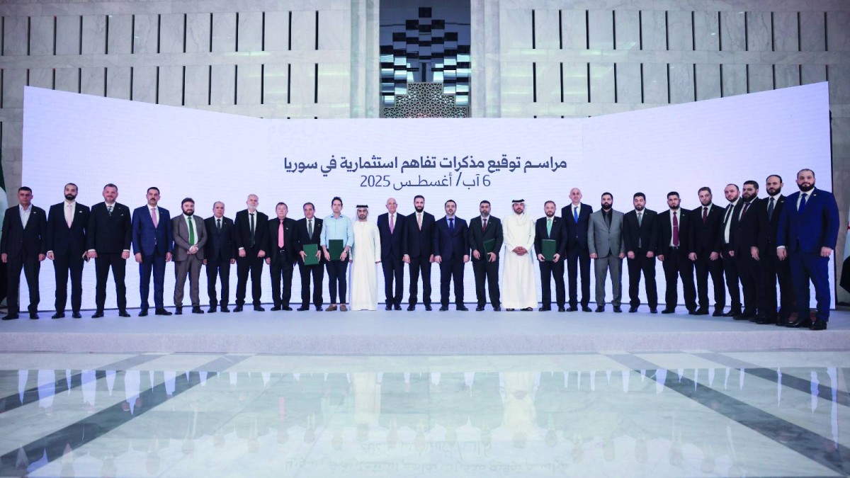 أحمد الشرع يتوسط ممثلي الجهات الموقعة خلال مراسم أقيمت اليوم | بلومبرغ