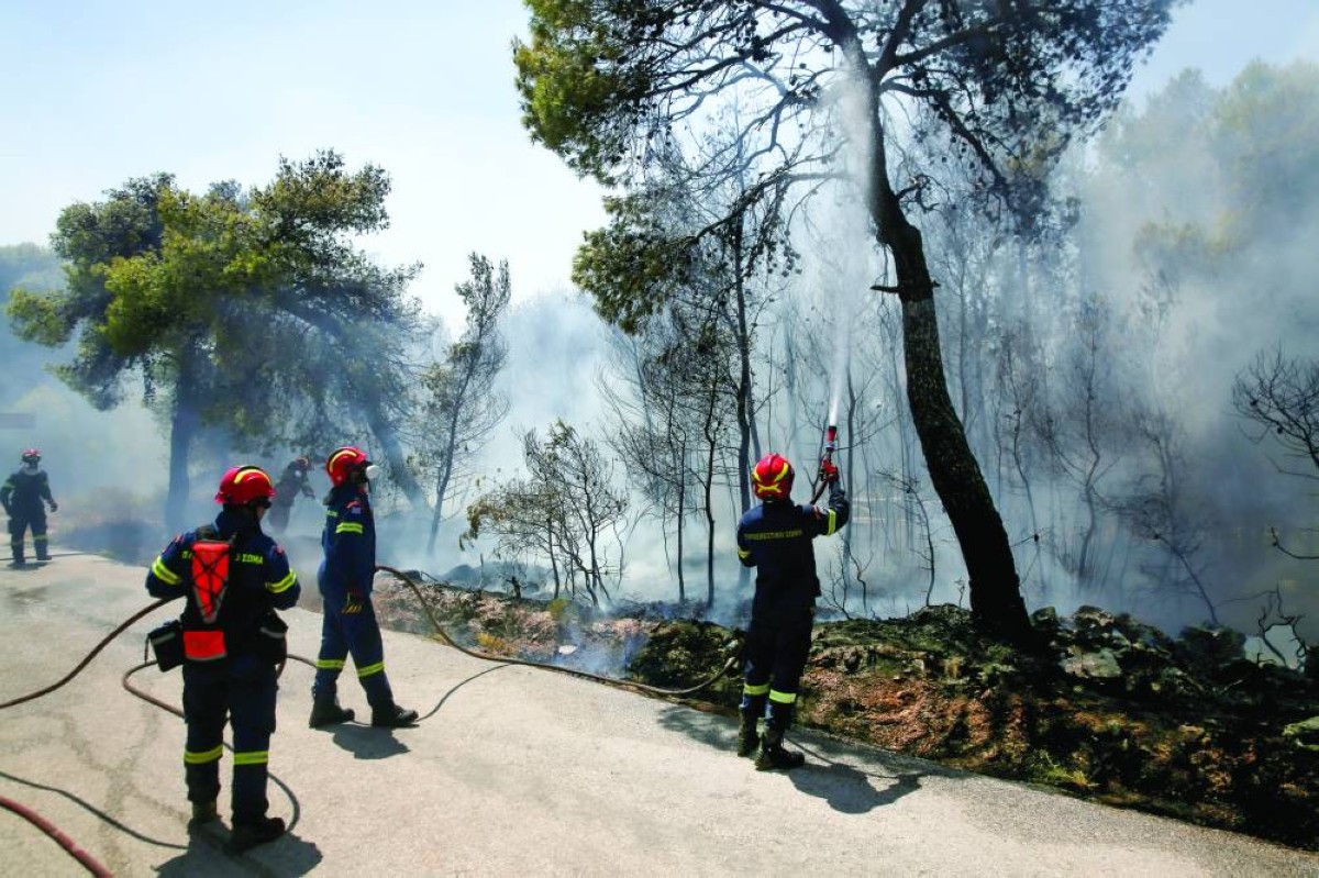 رجال إطفاء يكافحون حريقاً هائلاً اندلع في منطقة أتيكا جنوب شرقي اليونان