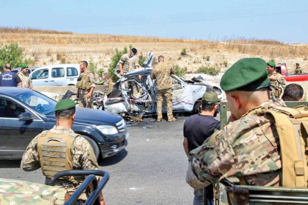 جنود لبنانيون يتفقدون حطام سيارة تعرضت لقصف إسرائيلي جنوبي صيدا