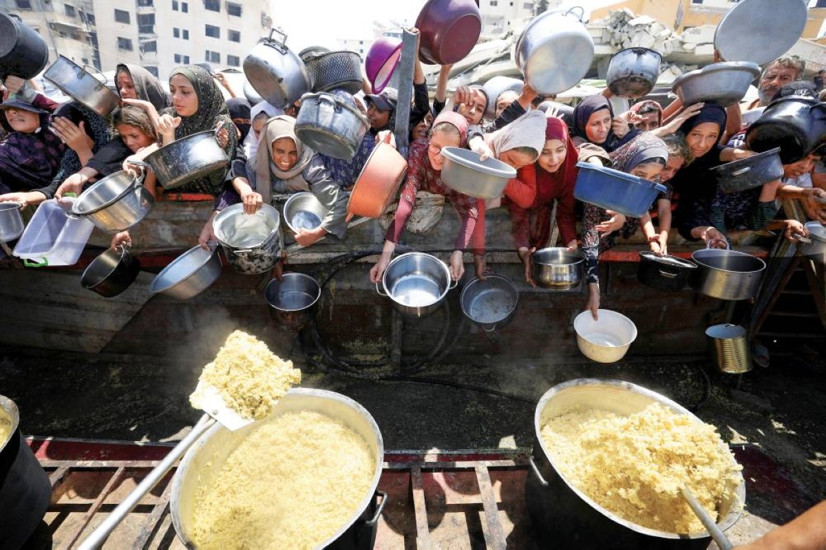 فلسطينيون ينتظرون الحصول على الطعام من مطبخ خيري في مدينة غزة