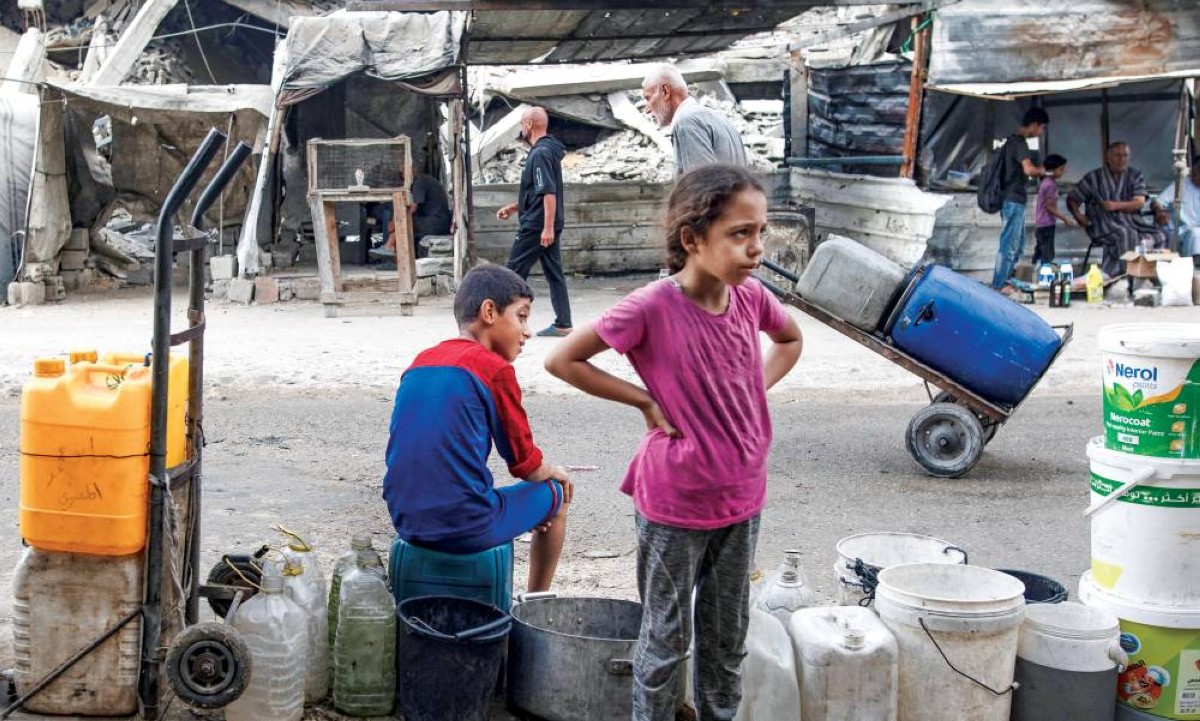 طفلان فلسطينيان ينتظران دورهما لتعبئة المياه من نقطة للتوزيع في خان يونس