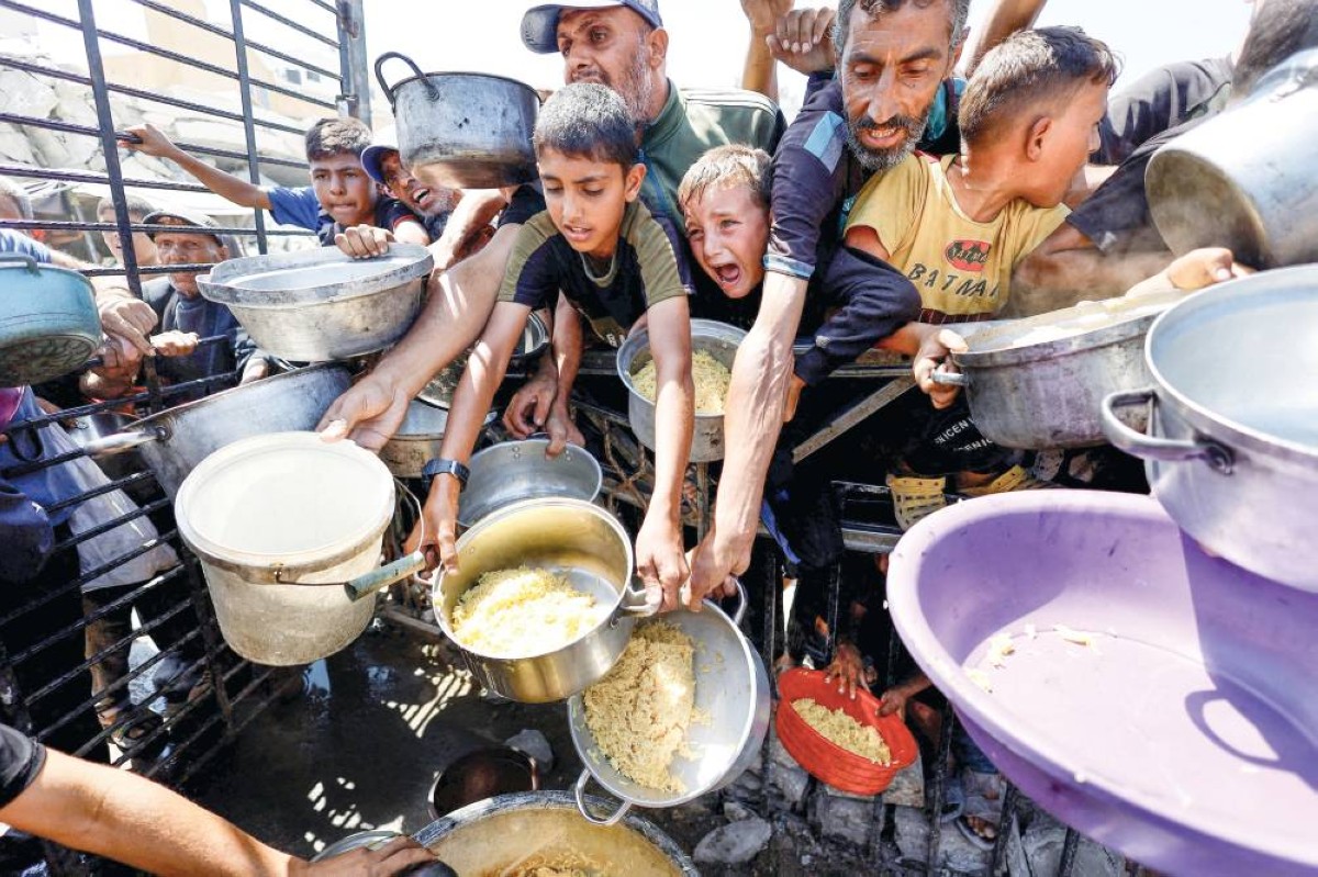 فلسطينيون ينتظرون الحصول على الطعام من مطبخ خيري بمدينة غزة