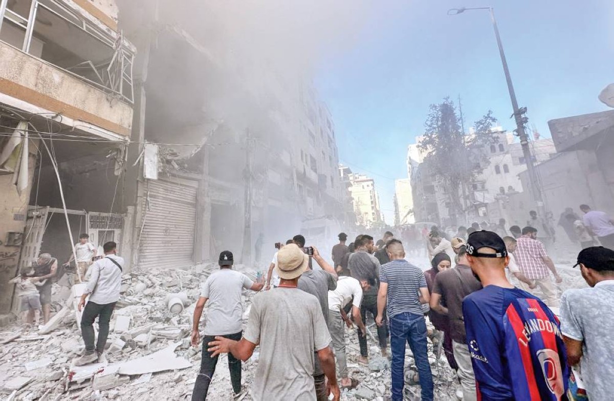 فلسطينيون يتجمعون في موقع غارة إسرائيلية استهدفت منزلاً في غزة