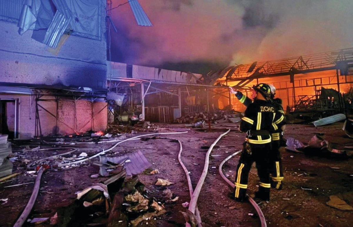 رجال إطفاء يعملون على إخماد حريق جراء غارة روسية في كييف 