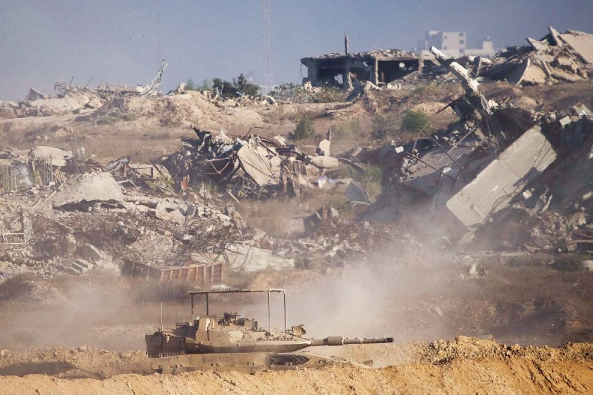 دبابة إسرائيلية تتمركز قرب أبنية مهدمة داخل قطاع غزة
