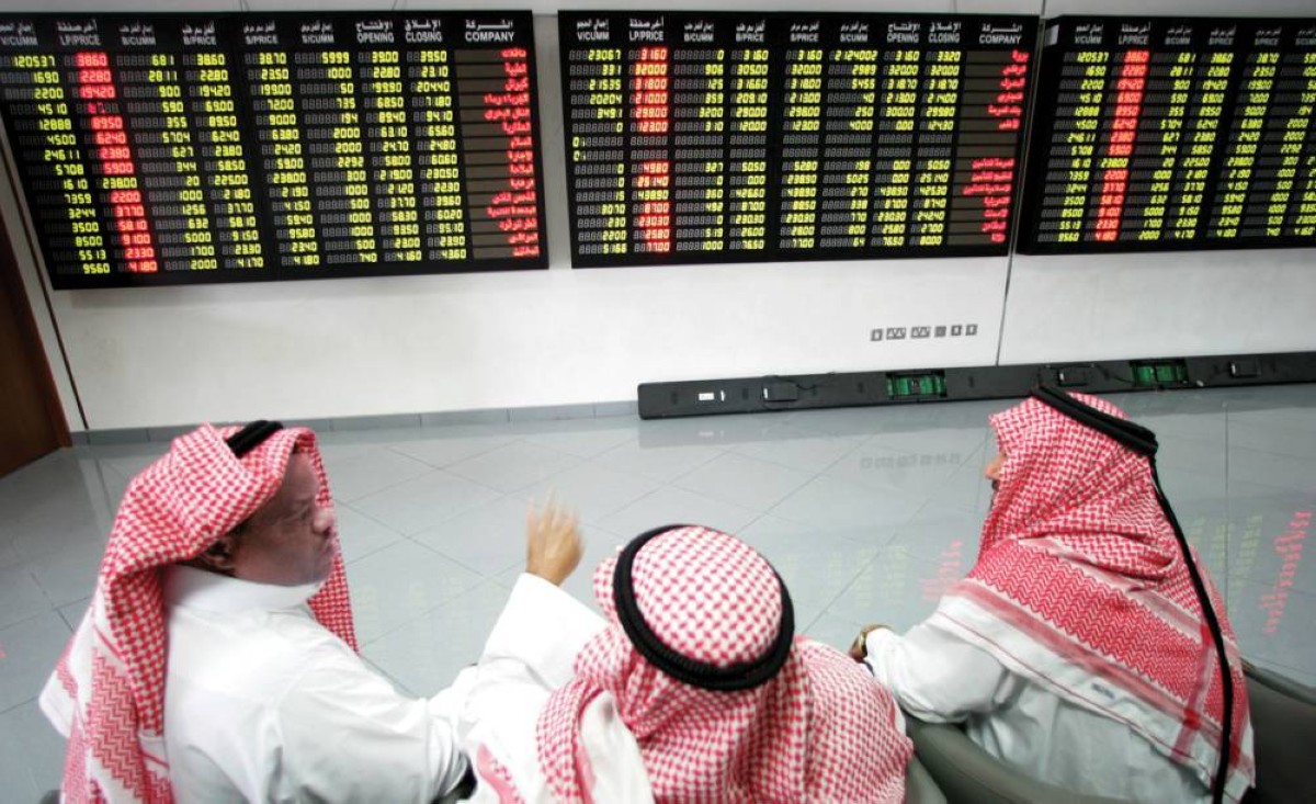 متعاملون يتابعون الشاشات في بورصة الدوحة