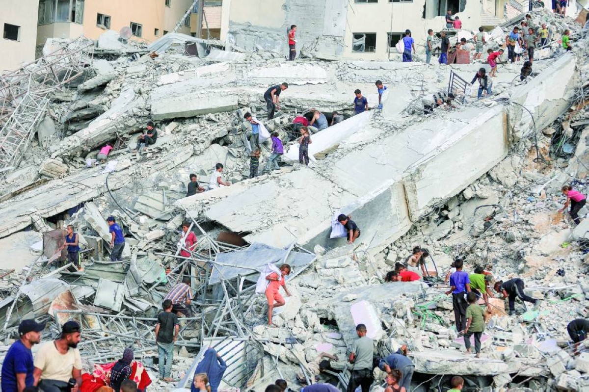 أطفال فلسطينيون يبحثون عن متعلقاتهم وسط أنقاض برج السوسي الذي دمرته غارة إسرائيلية جنوب غرب مدينة غزة 