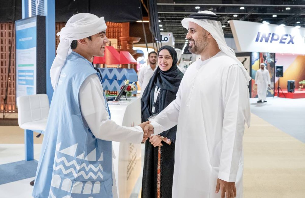  ذياب بن محمد مصافحاً أحد المشاركين في المعرض 