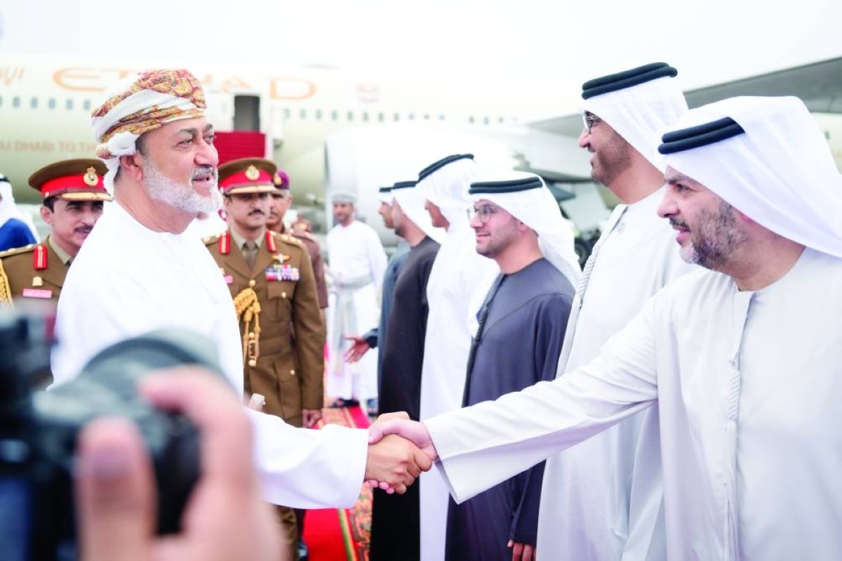 هيثم بن طارق مصافحاً فيصل البناي بحضور سلطان الجابر وأحمد المزروعي