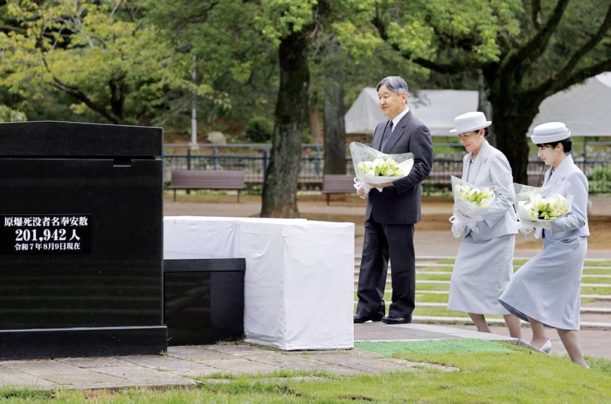 إمبراطور اليابان وزوجته وابنته يحملون باقات من الزهور البيضاء تكريماً للضحايا بحديقة السلام في ناغازاكي