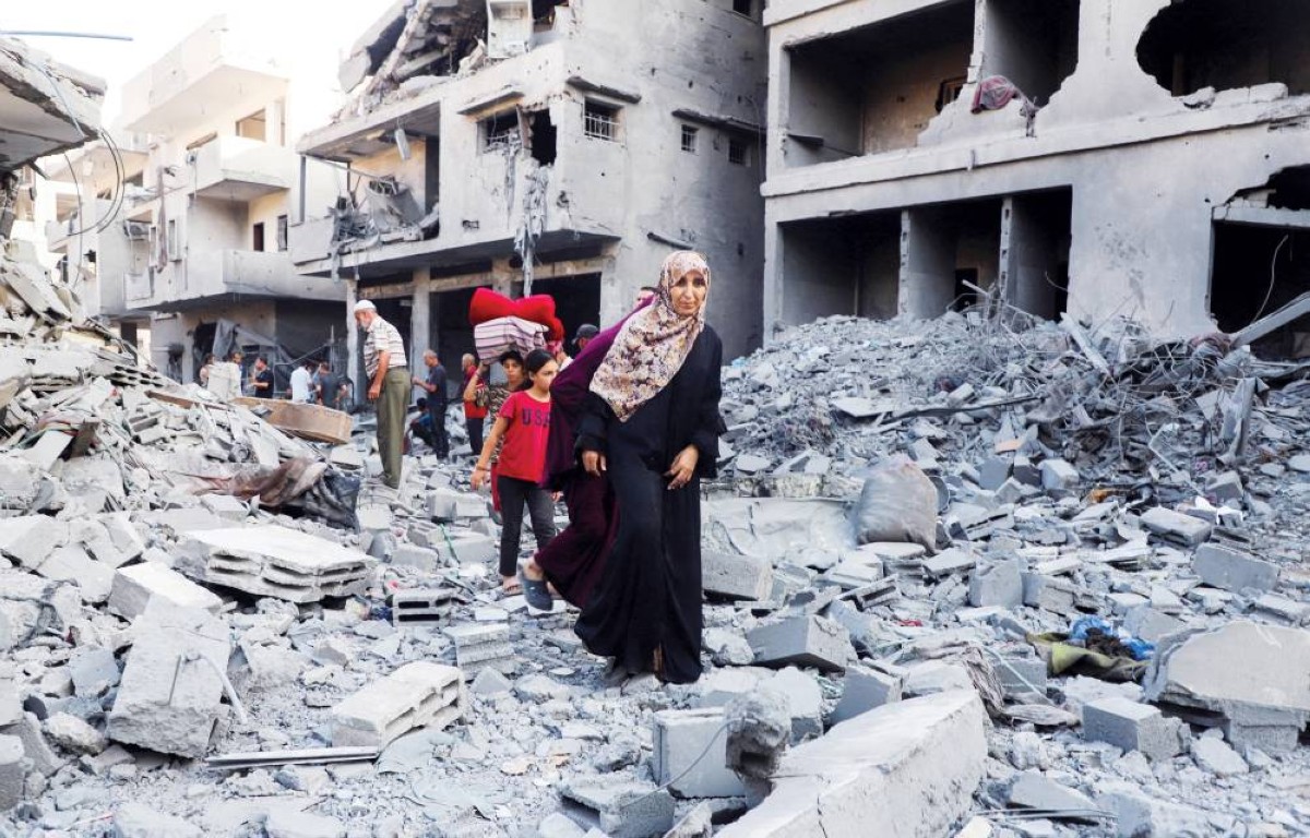 فلسطينيون يتفقدون ما خلفه القصف الإسرائيلي من ضحايا ودمار في أحد أحياء غزة