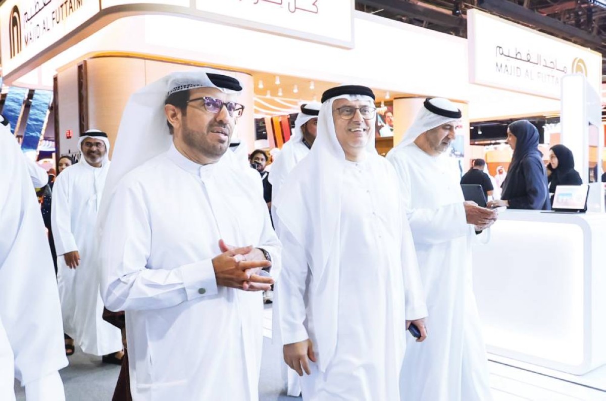 عبدالرحمن العور خلال جولته في المعرض بحضور أحمد المهيري