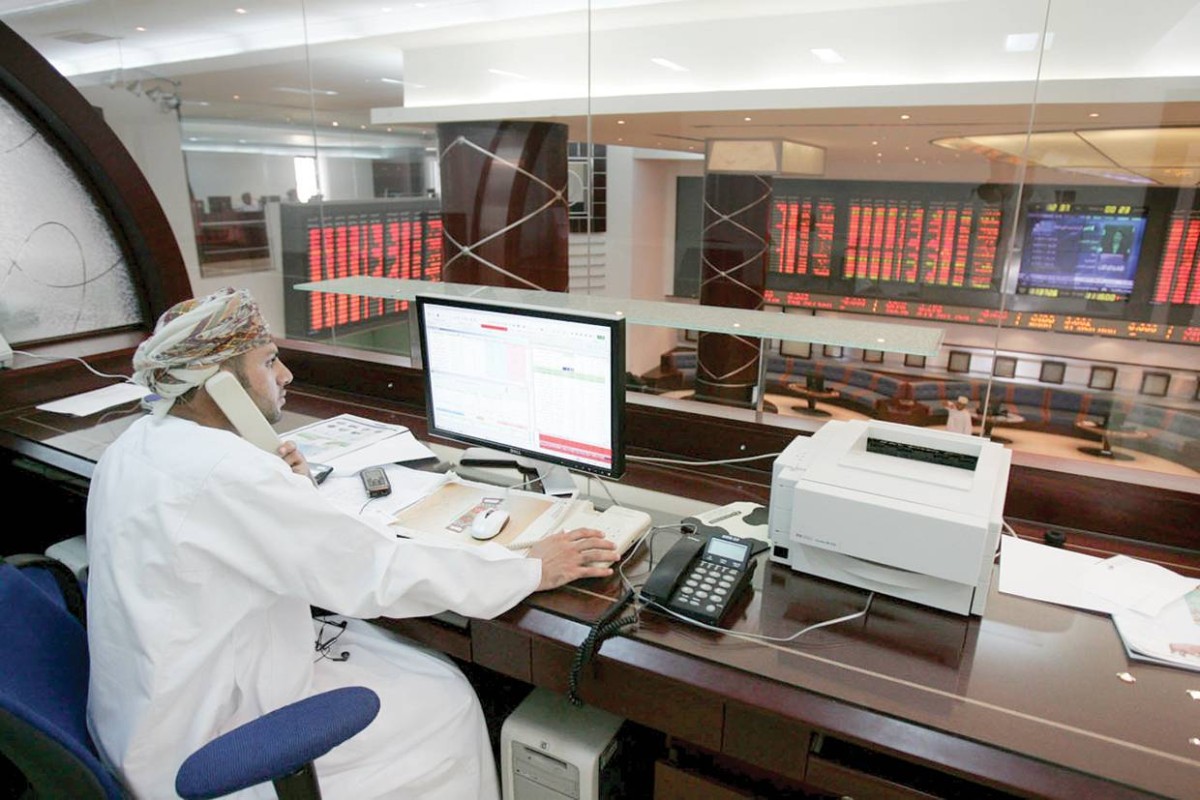 متعامل يتابع شاشات التداول في بورصة مسقط 
