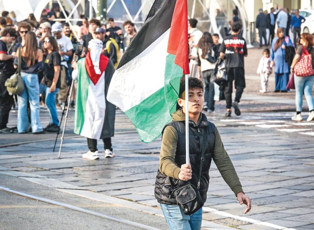 طفل يحمل علم فلسطين في مسيرة دعماً لغزة في ساحة كاستيلو بمدينة تورينو الإيطالية 