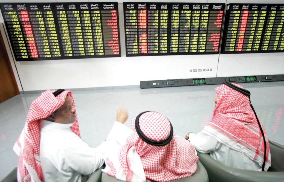متعاملون يتابعون شاشات للأسعار في بورصة قطر 