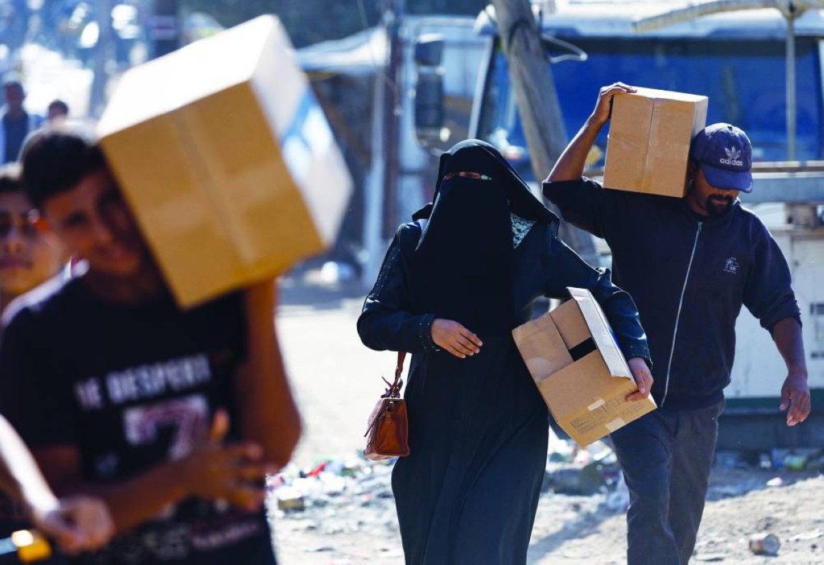 فلسطينيون يحملون مواد غذائية في الزوايدة وسط قطاع غزة 