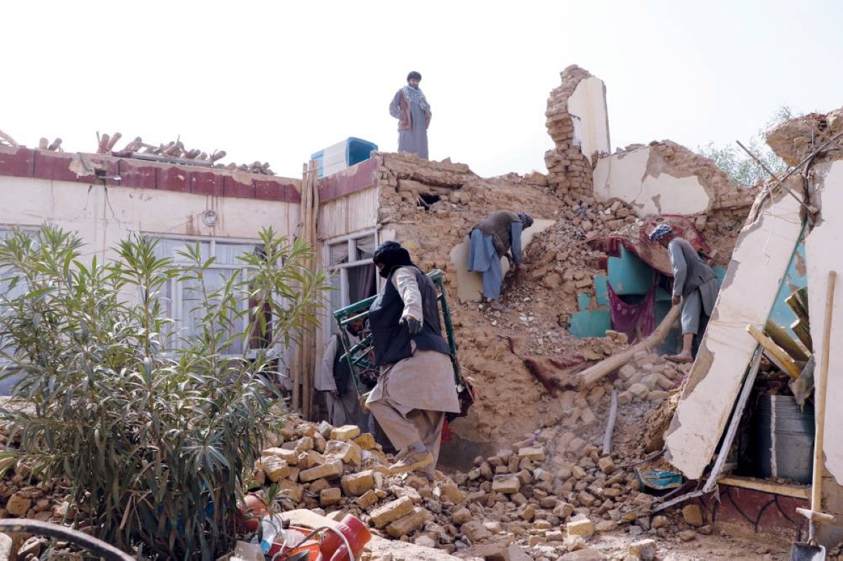 سكان يتفقدون مبنى متضرراً بعد الزلزال في مزار الشريف 