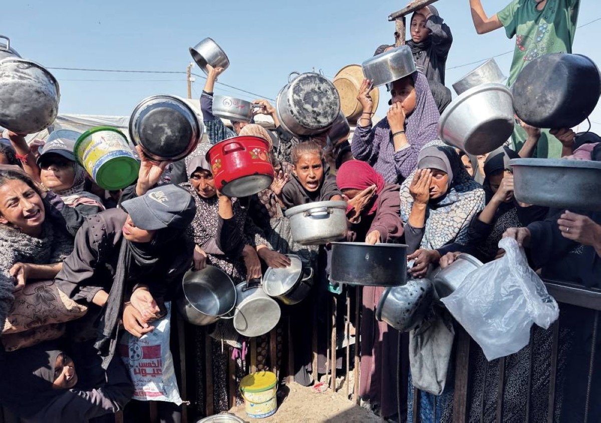 فلسطينيون يتجمعون لتلقي الطعام من مطبخ خيري في خان يونس