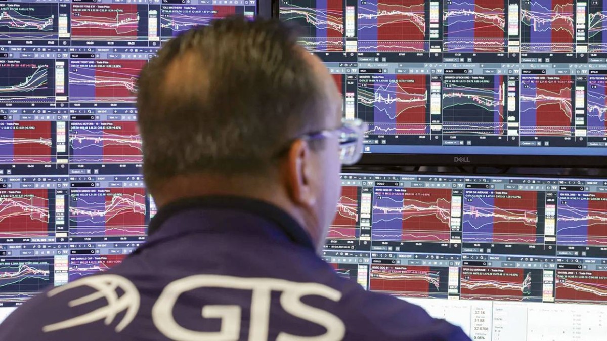 أحد المتداولين في بورصة نيويورك يتابع مؤشرات الأسهم