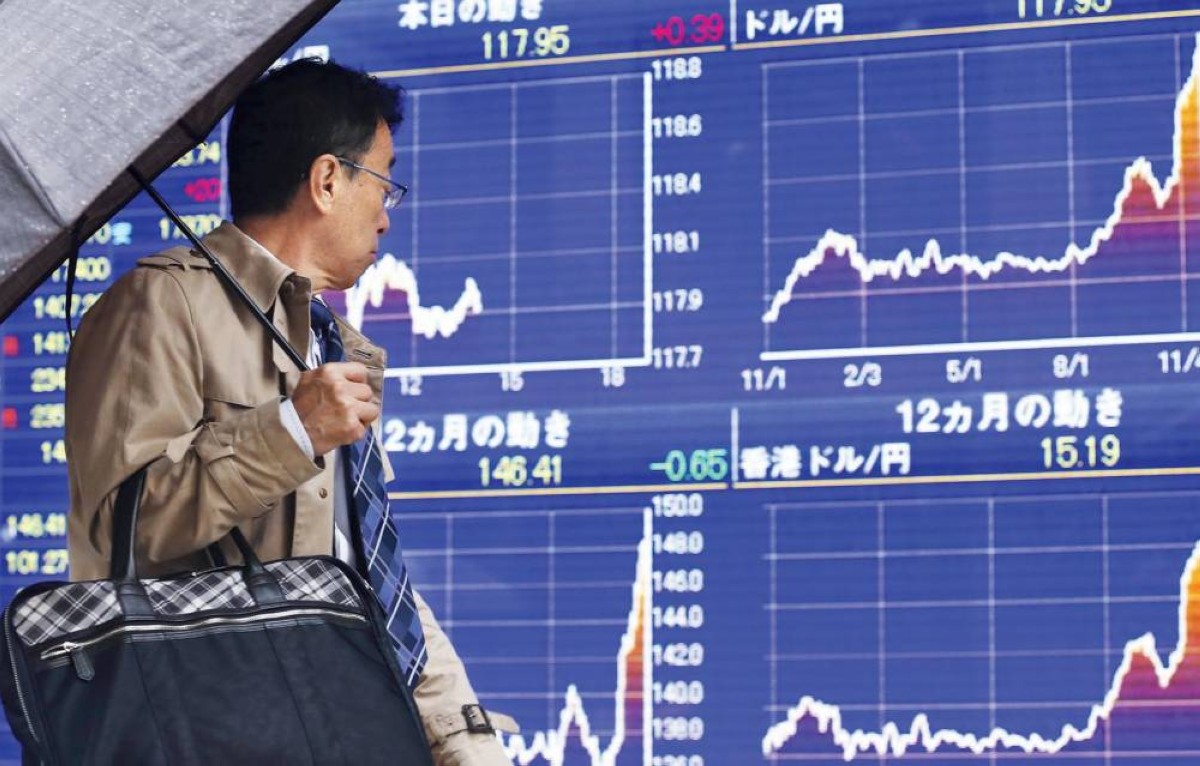 متعامل يمر أمام شاشات الأسعار في بورصة طوكيو


