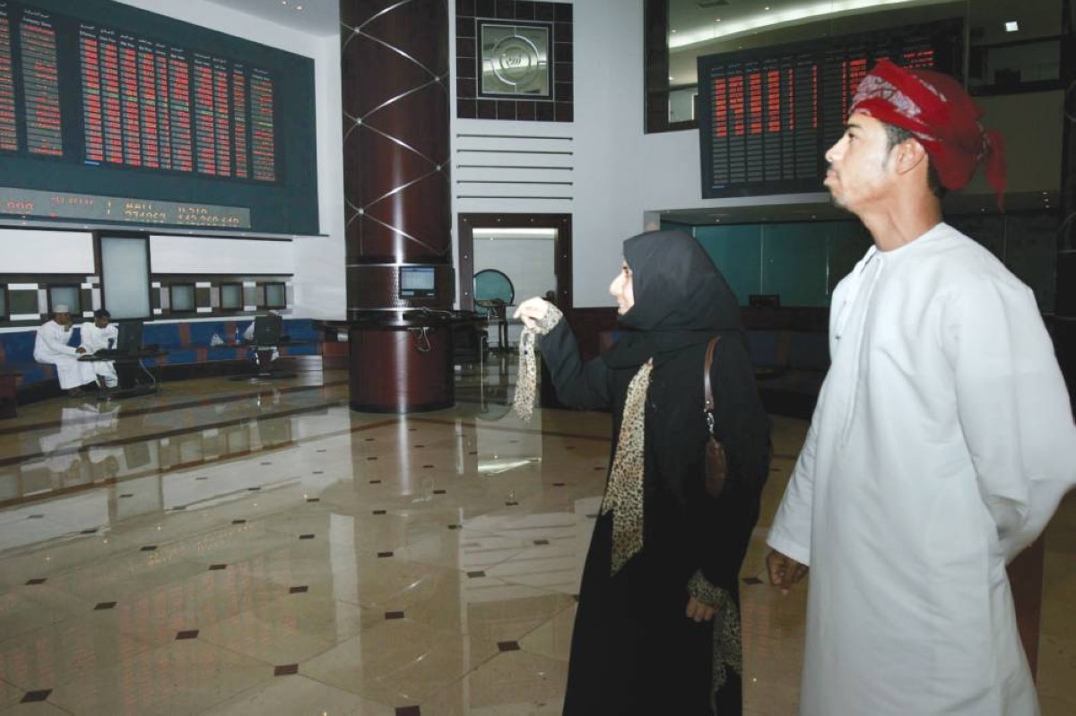 متعاملون يتابعون شاشات الأسعار في بورصة مسقط 
