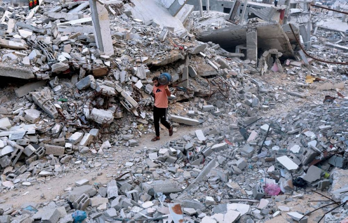 فلسطيني يسير بين أكوام الركام التي خلفتها غارات إسرائيلية في خان يونس جنوبي قطاع غزة
