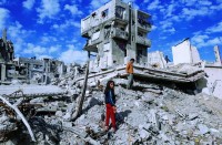 أطفال فلسطينيون يقفون بين أنقاض منازل عائلاتهم في مدينة غزة