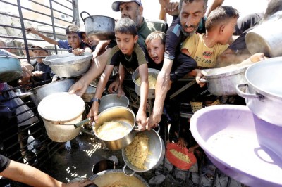 فلسطينيون ينتظرون استلام الطعام من مطبخ خيري في مدينة غزة |