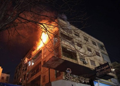 بناية تحترق بفعل الاشتباكات في أحد أحياء حلب الشمالية