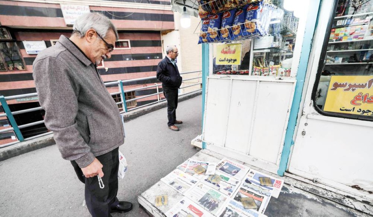إيراني يطّلع على الصحف اليومية التي تغطي الجولة الأولى من المحادثات بين إيران وأمريكا