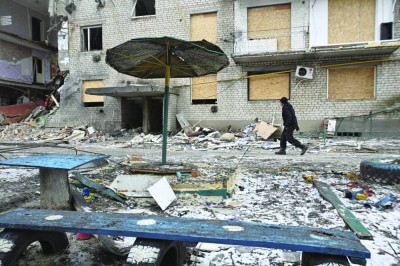 أحد السكان يسير بجوار مبنى سكني تضرر جراء غارات عسكرية روسية في بلدة كوميشوفاخا بمنطقة زابوروجيا