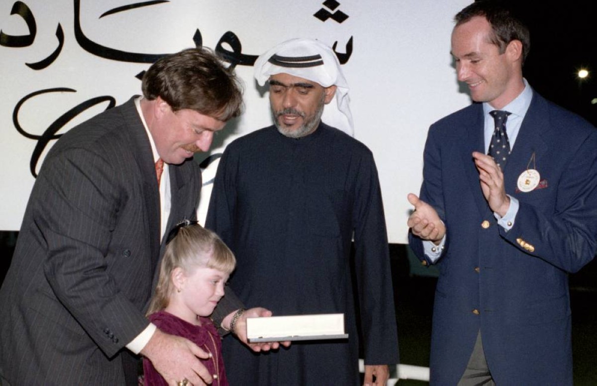 يسلم جائزة لأحد مدربي الخيول خلال سباق بمضمار نادي دبي في ند الشبا أرشيفية