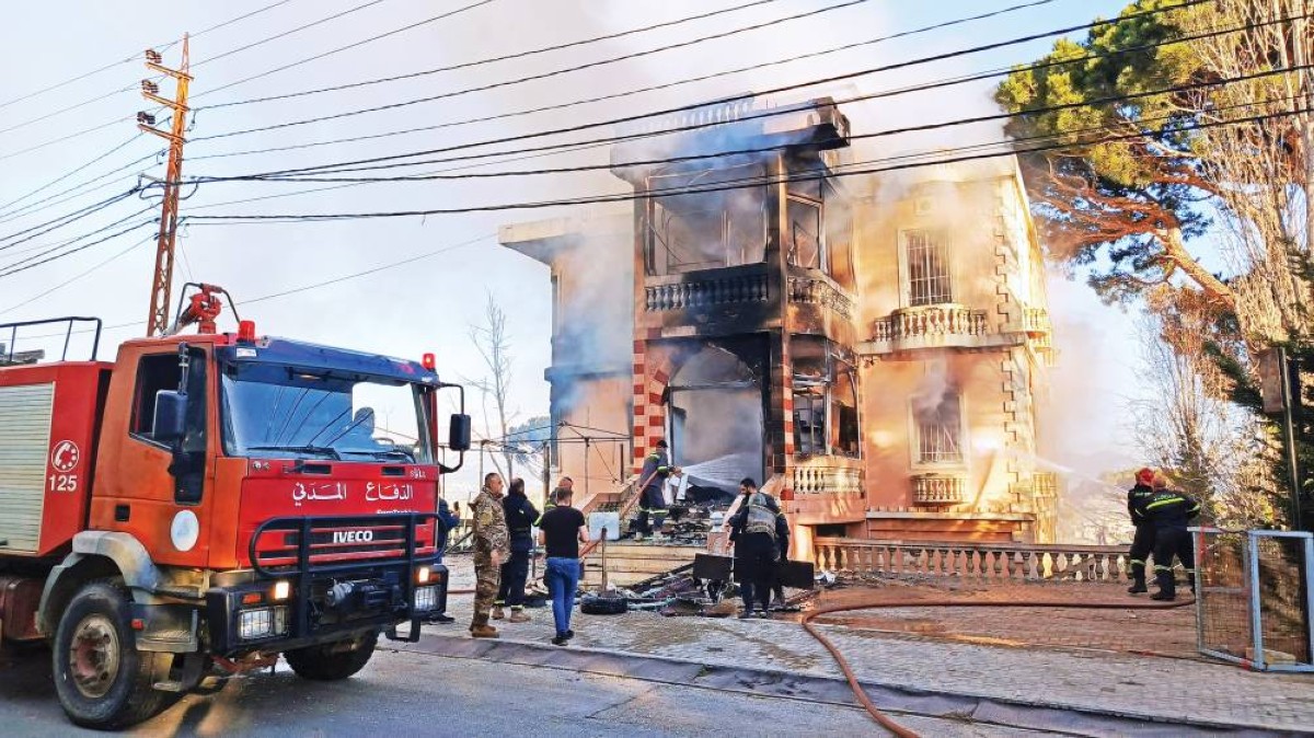 عناصر من الدفاع المدني يحاولون إخماد حريق بمبنى تعرض لقصف إسرائيلي في مرجعيون |