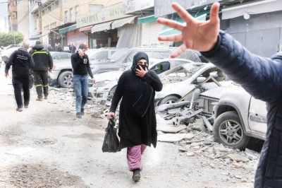 لبنانيون في منطقة لحقها التدمير إثر غارة إسرائيلية على بيروت