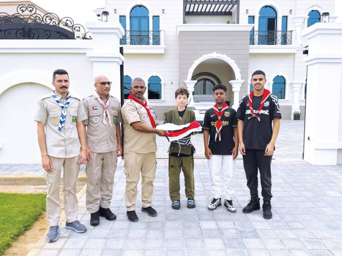 «كشافة دبي» توزع 1000 علم على المنازل